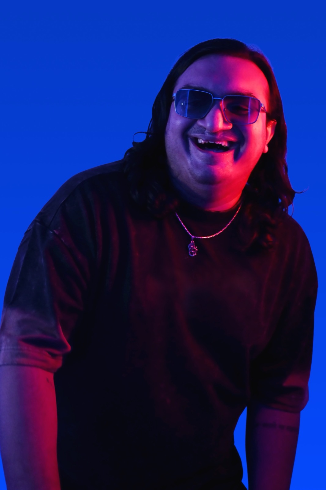 Sidallica laughing portrait in dual-tone blue and magenta light